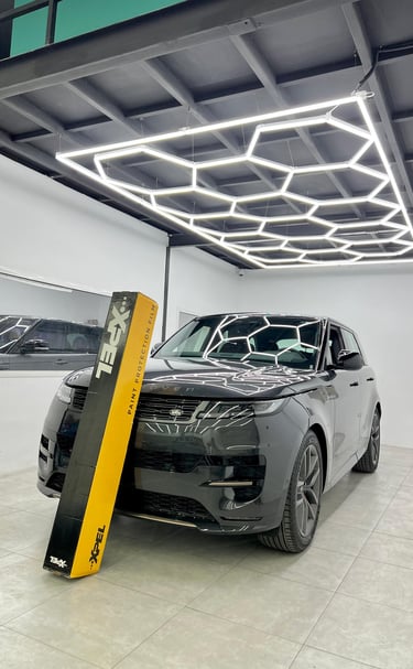 Black Land Rover Range Rover Sport with XPEL paint protection film in a professional detailing studio.