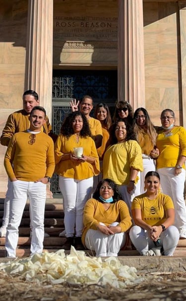 A group of people wearing yellow shirts and white pants pose for a photo at the Utah State Capitol.