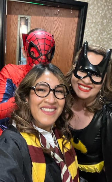 Three friends wearing Spider-Man, Batgirl, and Harry Potter costumes for a themed party or Halloween.