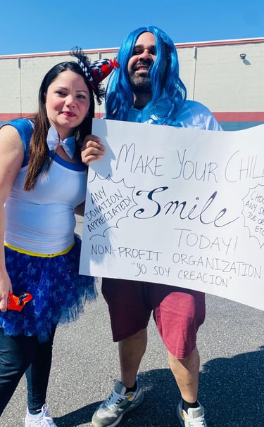 Volunteers in costumes hold a non-profit donation sign for Yo Soy Creacion outside a building.
