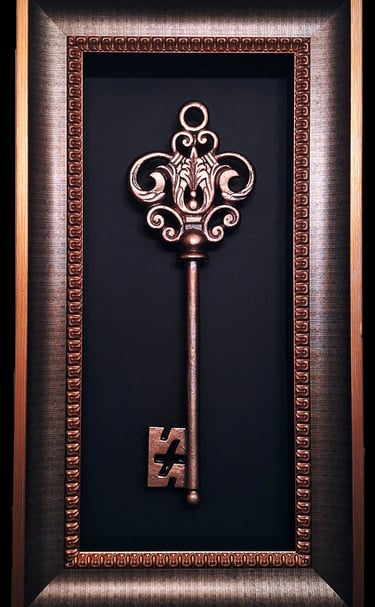 oversized decorative bronze key in a bronze frame
