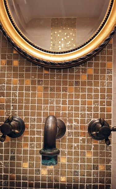 brass and bronze bathroom mirror with gold leaf mosaic tiles