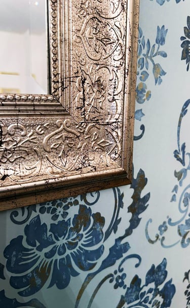 burnished silver mirror frame and soft teal wallpaper