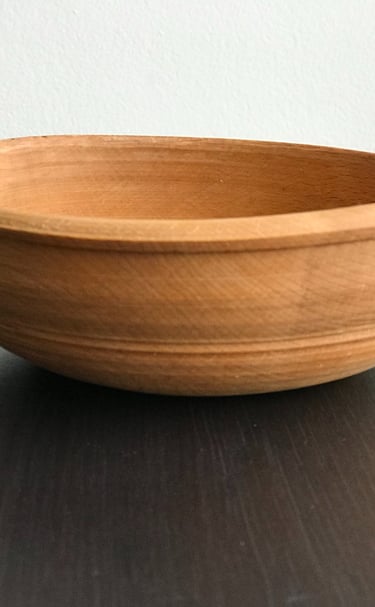 a wooden bowl with a wooden bowl on a table