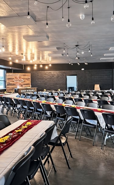 Wedding tables and chairs arranged beneath the warm brick interior of Brickyard Events, styled with 
