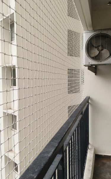Close-up of a sturdy balcony safety net installed on a high-rise apartment in Bangalore.