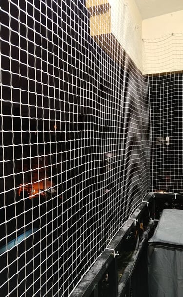 Close-up of a sturdy pigeon net securely installed on a balcony railing.