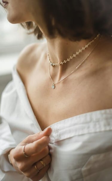 Mujer con hermoso juego de collares y anillos de oro