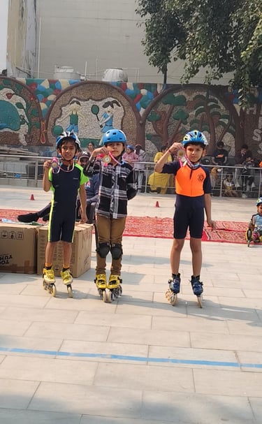 Three young boys in safety gear showing their medals at an outdoor inline skating competition.