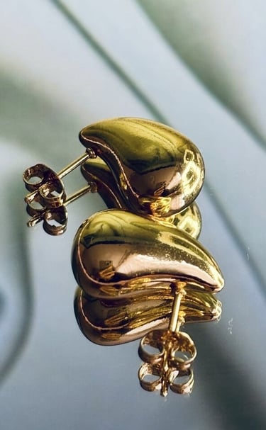 Aretes dorados chunky de Moreina Joyería con diseño minimalista y elegante, fotografiados sobre fondo suave.