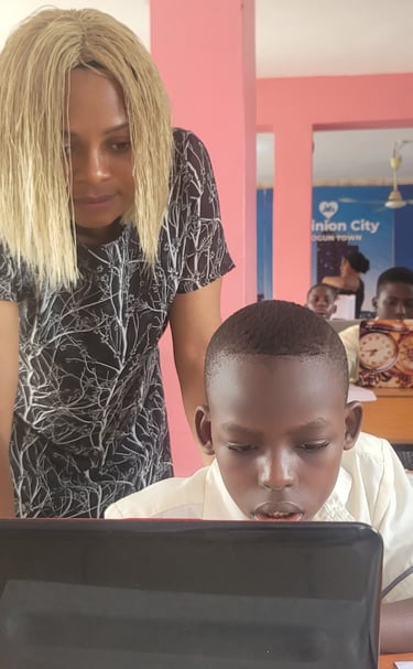 A female digital literacy instructor guiding a pupil on a computer project in class