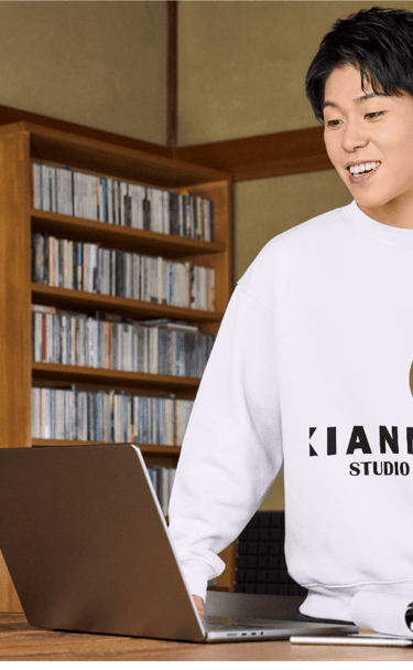 Un hombre en la oficina de trabajo vistiendo la chompa con el logo de Xianna Studio
