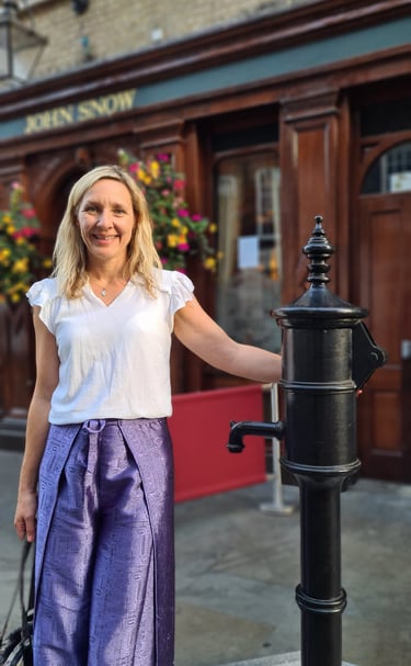 Dr Helena Seth-Smith standing at the John Snow water pump, London