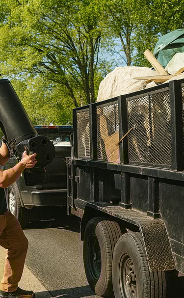 a man is carrying a large black object in a truck