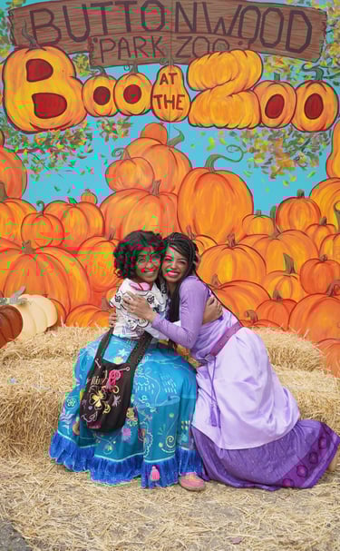 Mirabel and Asha hug for a photo at a fall festival