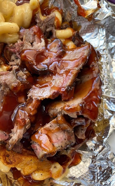 Signature One Eye Willy brisket mac and cheese—Texas-style smoked brisket over four-cheese macaroni with BBQ drizzle, served 