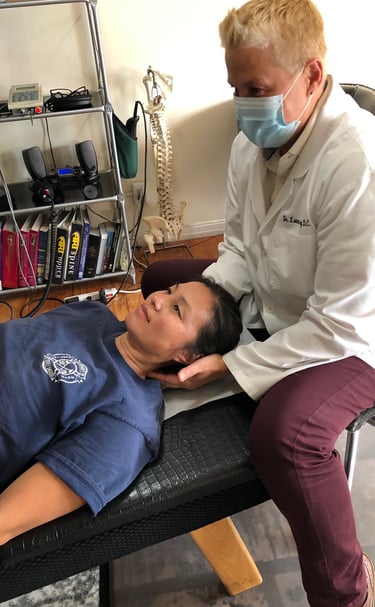 Dr. Lonna Denny performing traditional neck adjustment to one of her patients.