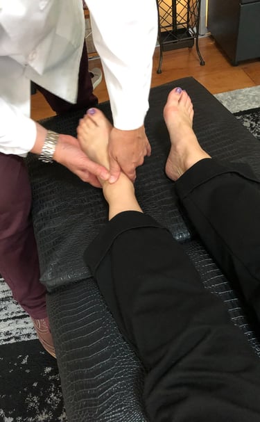 Dr. Lonna Denny performing a traditional adjustment to a patient.'s ankle