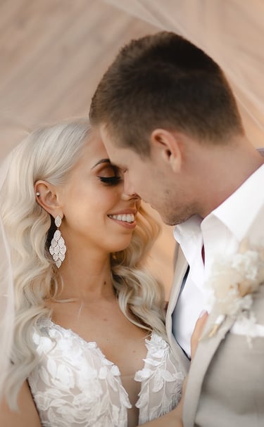 a bride and groom standing in front of a wooden wall