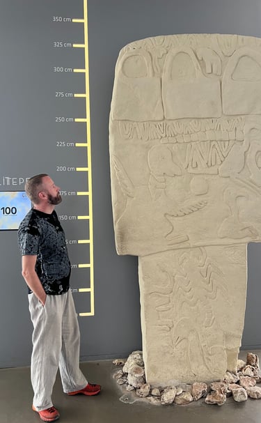 A man looks up at a reconstruction Pillar 43 at Gobekli Tepe