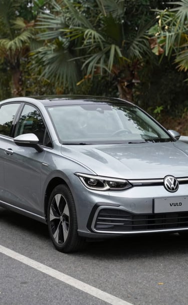 Smiling customer shaking hands with a sales representative beside a white SUV.