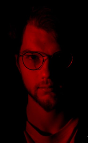 Thomas Rateau, le bassiste du groupe Rush On Mars éclairé de face par une Lumière rouge 
