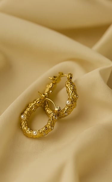 a pair of gold earrings with pearls and pearls
