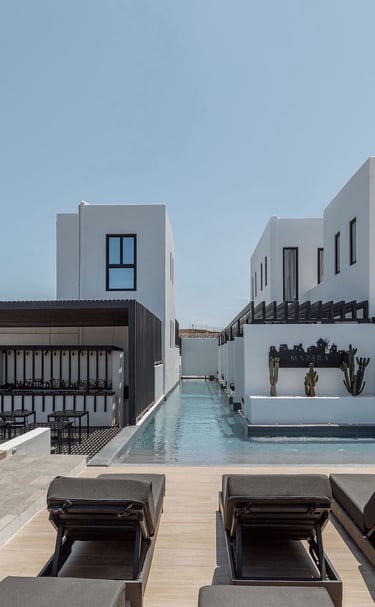 a pool with lounge chairs and a pool