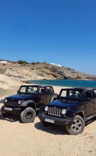 two jeeps parked on a sandy beach
