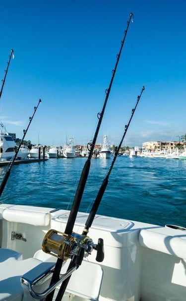 Fishing rods on a luxury yacht charter departing from a scenic tropical marina.