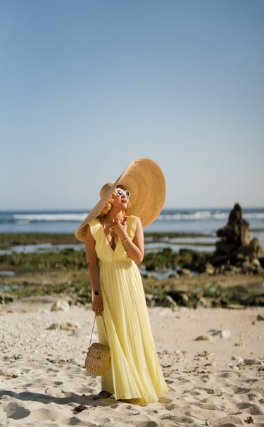 Portrait of woman standing on beach wearing wide sun hat at Melasti Beach Bali