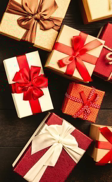 varios regalos sobre una mesa con moño rojo