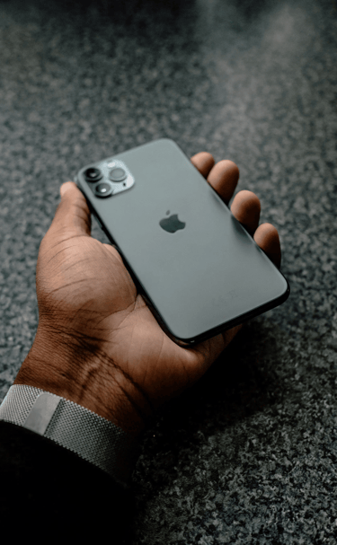 un hombre sosteniendo un iphone negro 