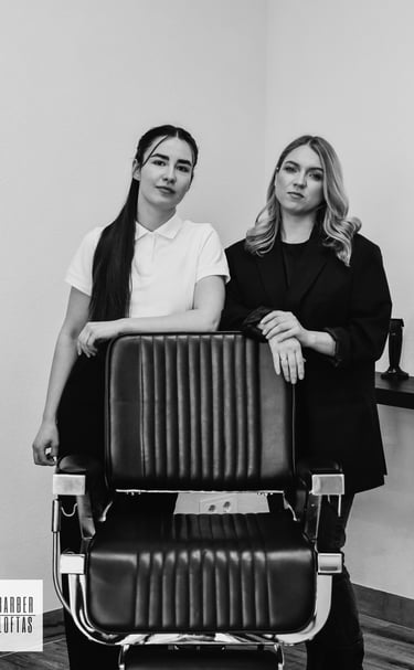 two women standing in front of a hair salon