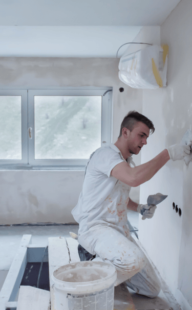 Imagen de pintor haciendo reparaciones en un pared.