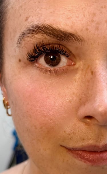 Close-up of wispy lash extensions over open fans, in Bird Rock