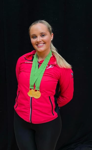 a woman in a red jacket and a medal. just received 2 gold medals