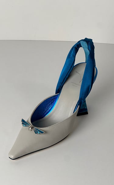 Judy Mazzotti pair of shoes with a blue ribbon tied to a shoe