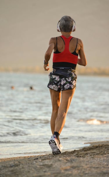 Woman running on the beach with a tennis racket