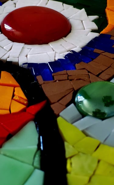 a colorful mosaic tile table with a red and white flower