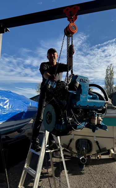 Mechanic fixing an outboard motor electrical issue at a marina in St. Catharines.