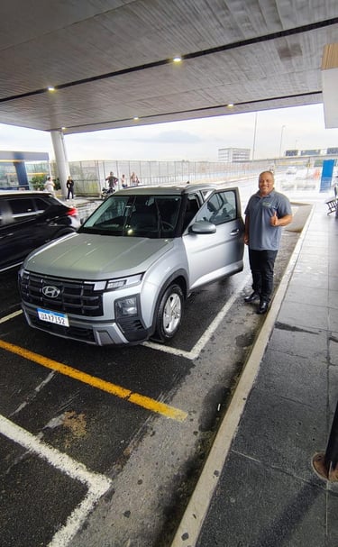 Motorista ao lado do carro posando para foto após finalizar mais uma viagem