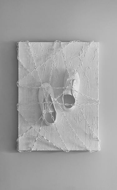 shoes tied by chains to a plastered canvas with footprint