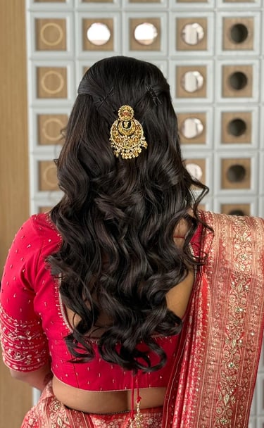  Elegant bridal hairstyle with a traditional gold hair accessory and soft curls for a Gujarati bride