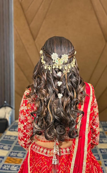 Intricate bridal hair weave with floral pins and heavy jewelry for a wedding look in Vadodara.