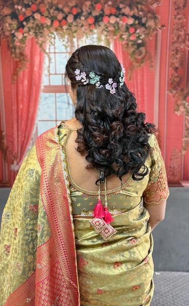 A beautiful open variation bridal hairstyle with a braided crown and purple-green floral accessories