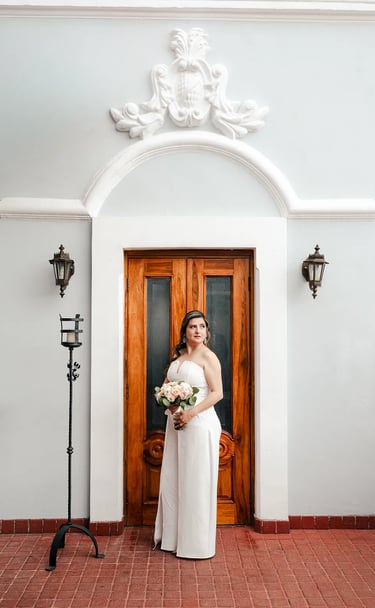 Novia en el día de su boda posando elegante con su ramo de flores en el centro histórico de Quito