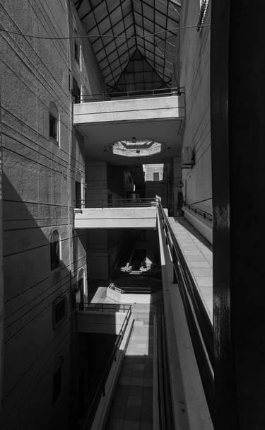 Black and white architectural photography of building interior with harsh shadows. Unseen Spaces