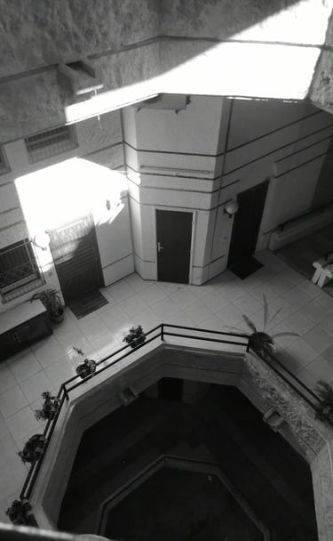 Black and white high-angle shot of brutalist building courtyard with tiled floors. Unseen Spaces