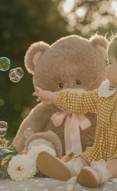 a baby doll sitting on a blanket with bubbles